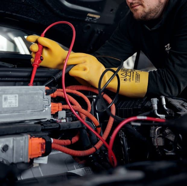 Messspitzen und Isolierhandschuhe am Hochvolt-System eines Elektroautos