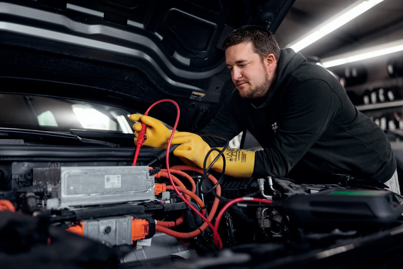 Messung am Hochvolt-System eines Elektroautos mit isolierenden Schutzhandschuhen